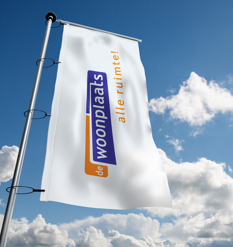 Een witte vlag met het logo van De Woonplaats erop aan een paal