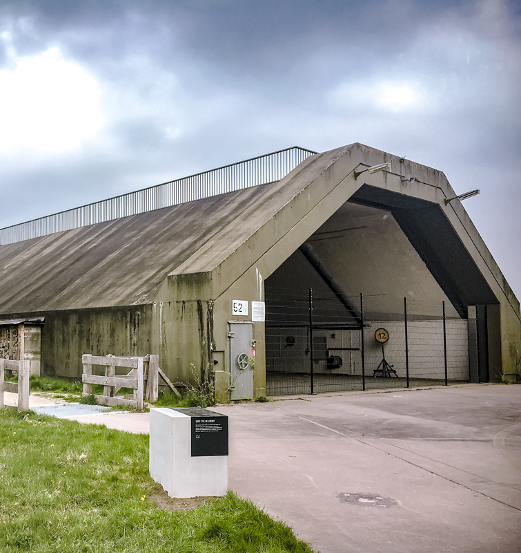 Hangar van de voormalige vliegbasis Twenthe met een informatief bord ervoor