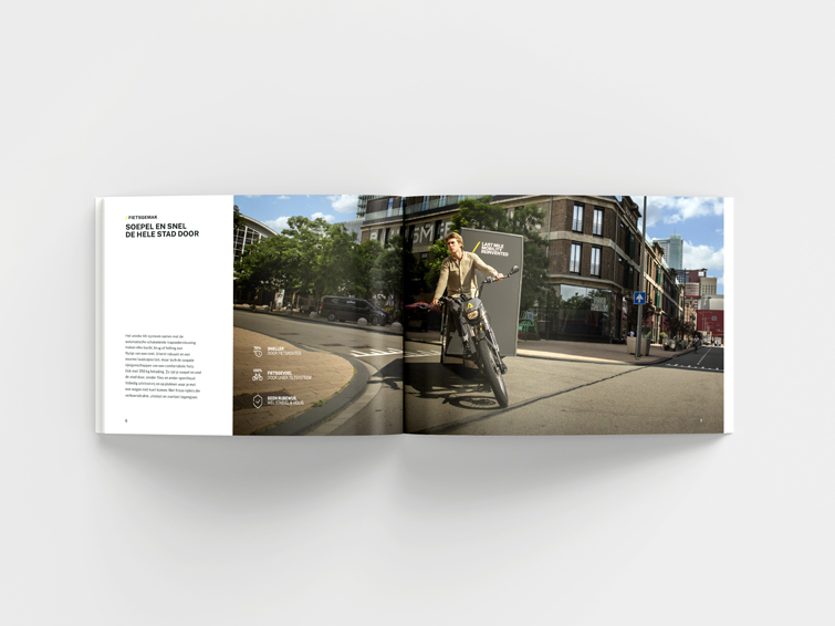 Opengevouwen boek over de Fulpra met een afbeelding van een man die op een Fulpra de bocht om fietst