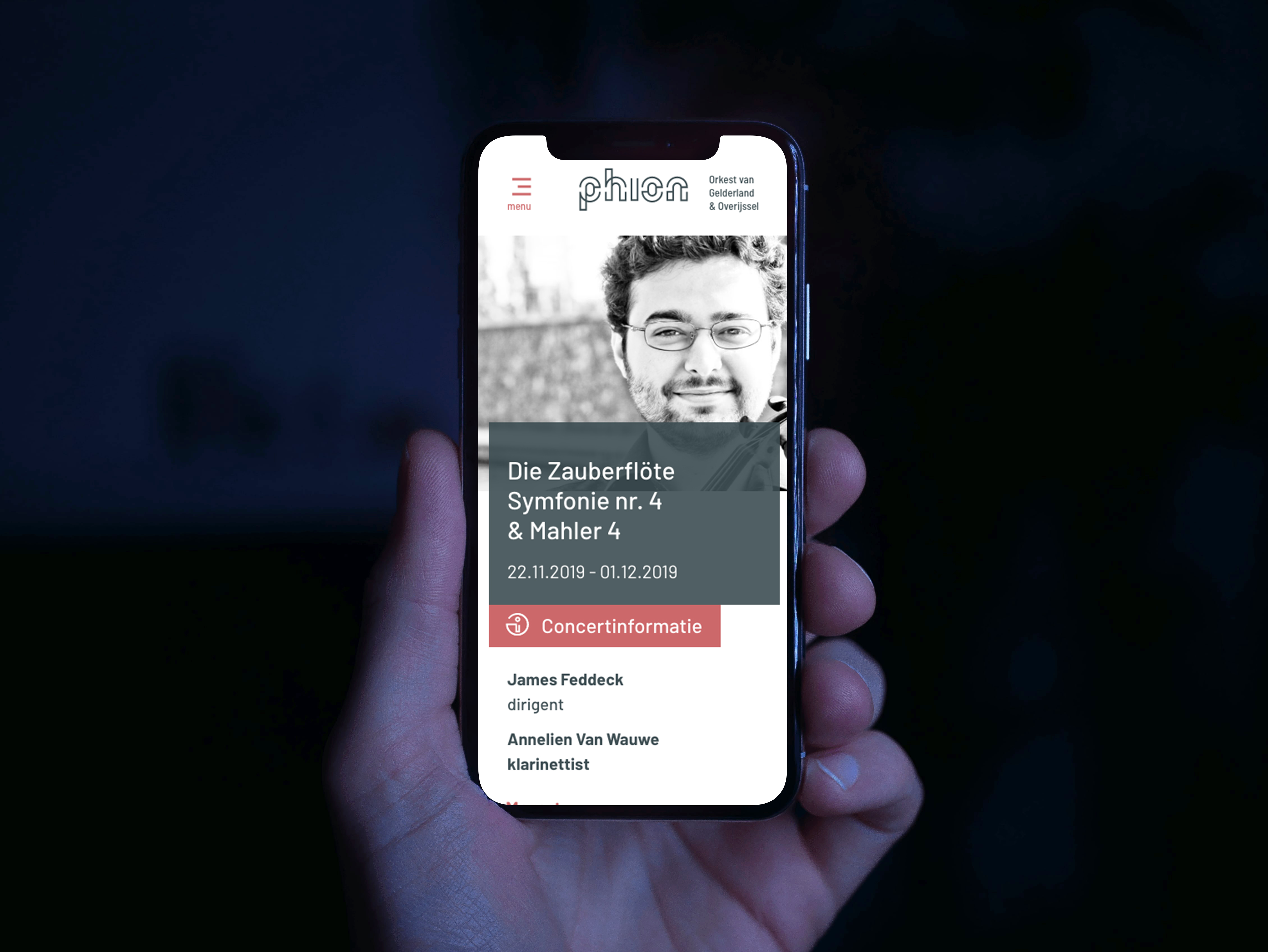 Hand die telefoon vasthoudt met daarop de website van Phion