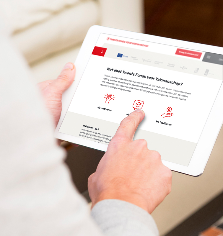 Persoon die een iPad vasthoudt met daarop de site van Twents Fonds voor Vakmanschap