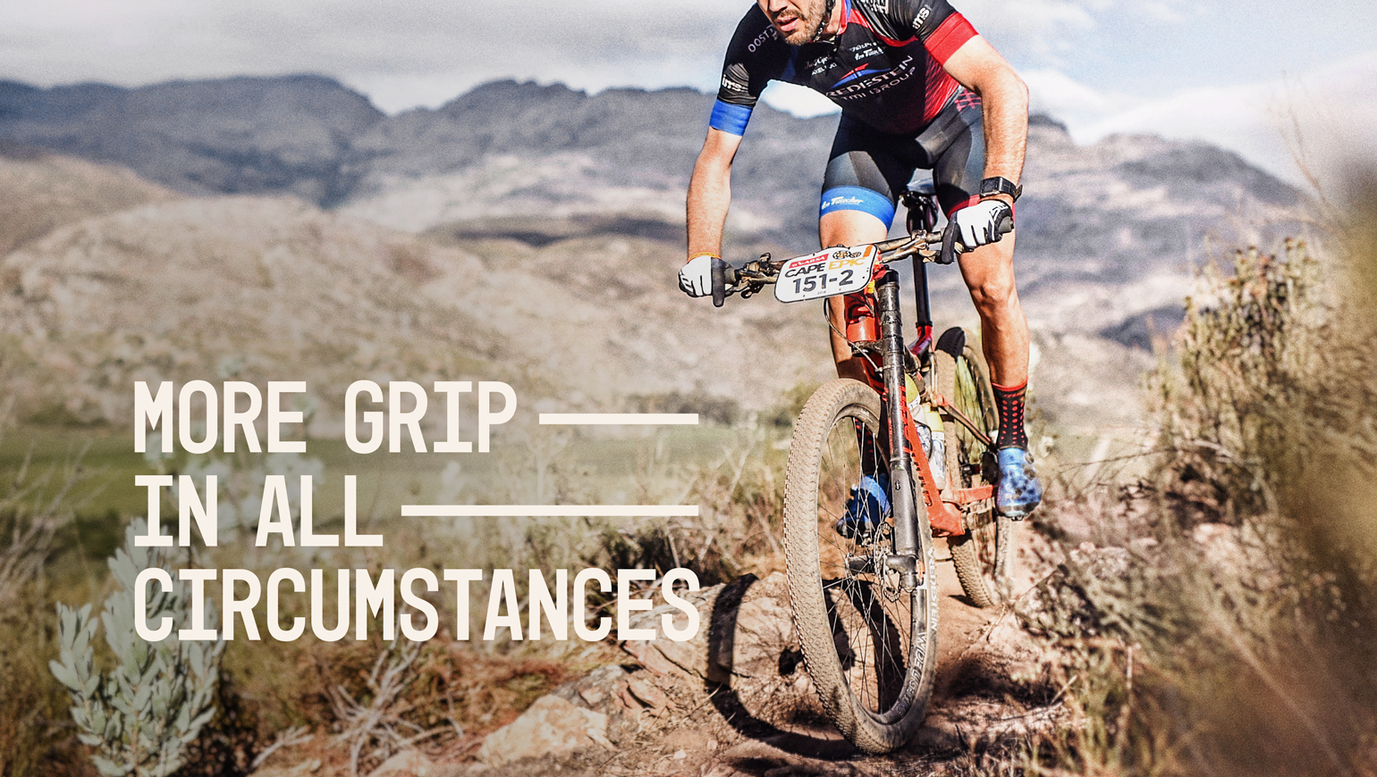 Man fietst op mountainbike met Vredestein banden door een bergachtig landschap