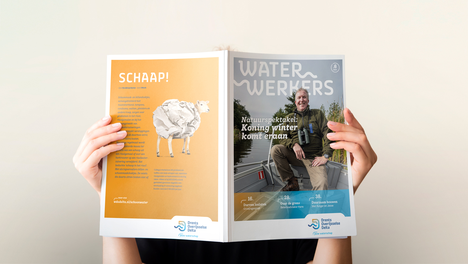 Persoon die het Drents Overijsselse Delta magazine open doet voor zijn gezicht met op de voorkant een man in een boot